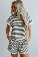 Woman wearing a black and white striped loungewear set, side view with hands in pockets