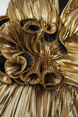 Close-up of the ruffled floral detail on the bust of a gold metallic tiered dress.