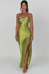 Woman wearing a long olive green satin slip dress with spaghetti straps and a high slit.