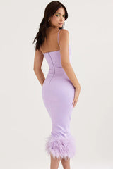 back view of a woman in a lavender midi dress with feather trim