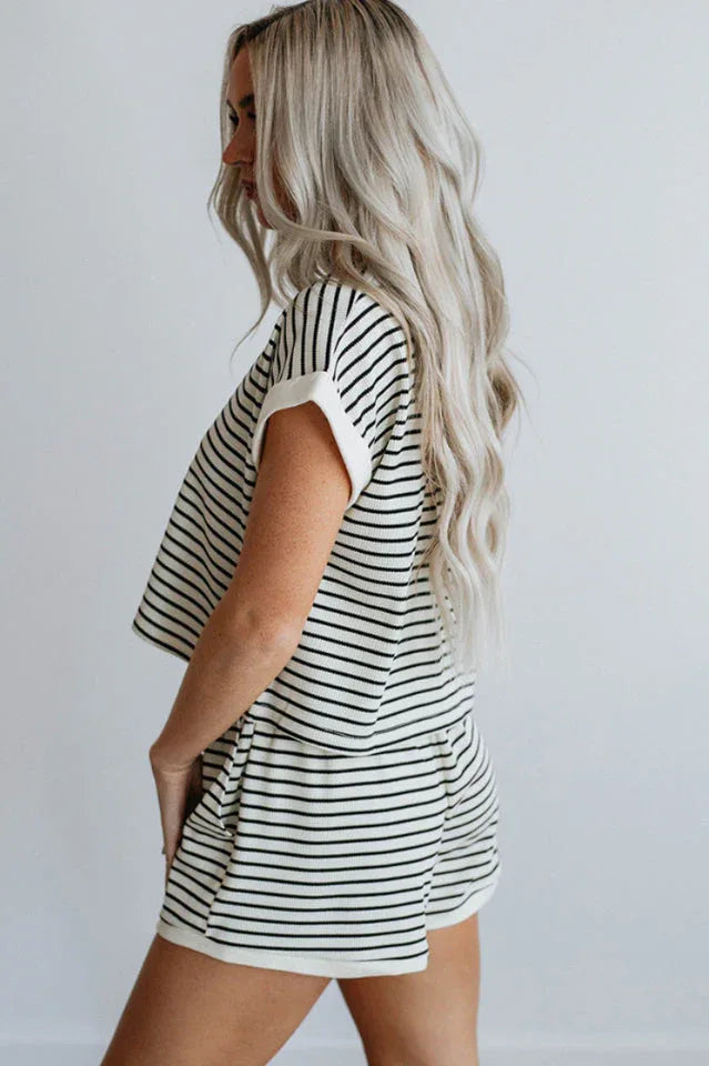 Woman wearing a black and white striped loungewear set, side profile