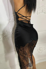 back view of a woman in a black satin slip dress with criss-cross straps