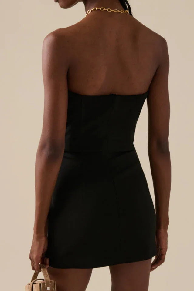 Back view of a black strapless mini dress.