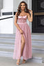 Woman in a pink tulle maxi dress with a sweetheart neckline and spaghetti straps.