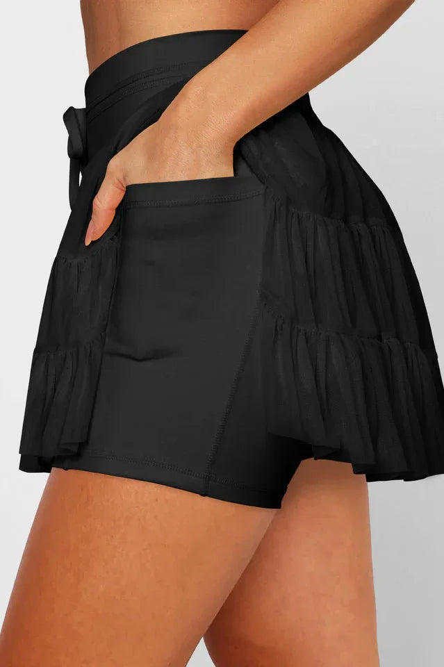 Close-up of the black tiered ruffle skirt showing the side pocket and built-in shorts.