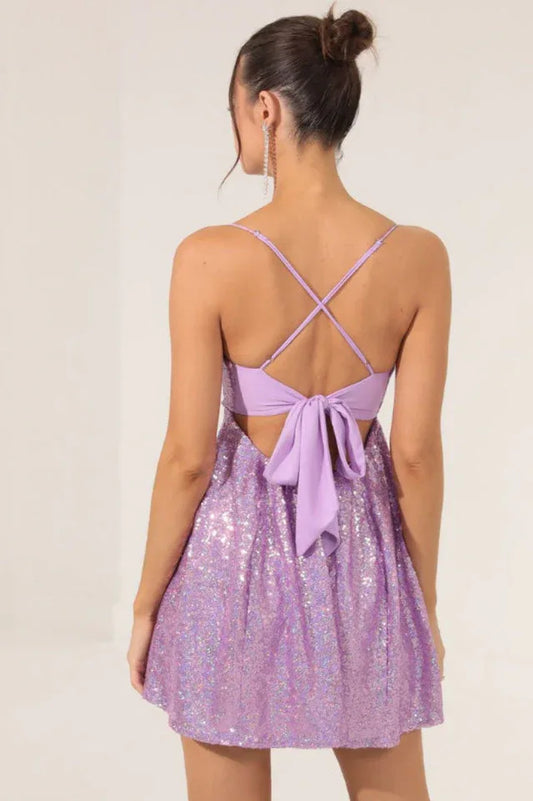 back view of a purple sequin mini dress with spaghetti straps and a tie detail