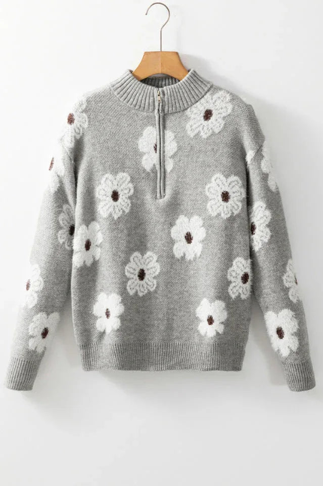 A gray floral print quarter-zip knit sweater with a mock neck, long sleeves, and ribbed cuffs and hem, displayed on a hanger.