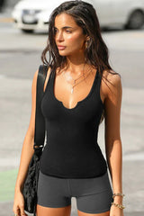 Close-up of a woman in a black ribbed tank top with a scoop neckline.