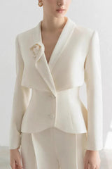Close-up of the peplum jacket with lapel detail and floral accent.