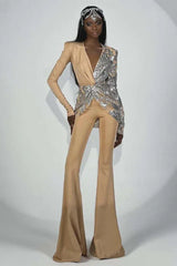 Woman wearing a tan and silver sequined jumpsuit with flared legs and a deep V-neck, accessorized with a jeweled headpiece.