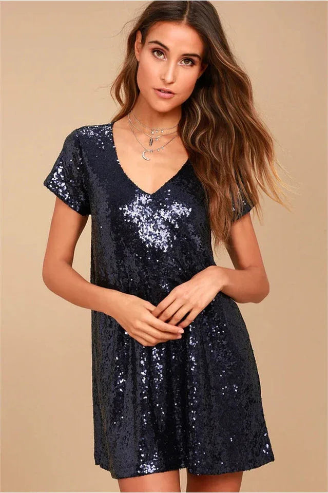 woman wearing a short, navy sequin shift dress with a v-neckline and short sleeves