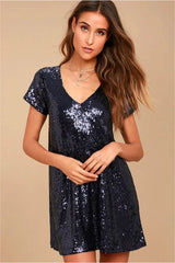woman wearing a short, navy sequin shift dress with a v-neckline and short sleeves