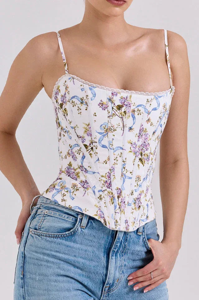 Front view of a woman in a floral print corset top with lace trim and adjustable straps.