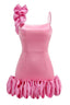back view of a bright pink mini dress with a large ruffle on one shoulder and a ruffled hem, showing zipper detail