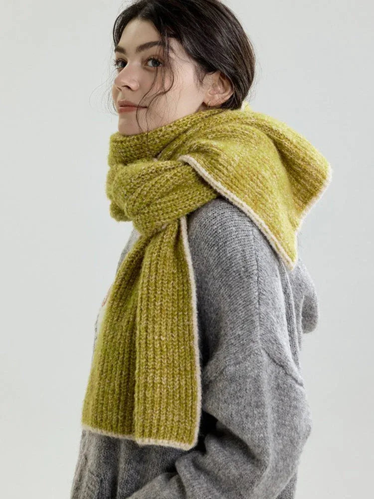 Close-up profile of a model wearing a lime green chunky knit scarf with contrasting trim.