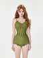 Model wearing a green floral print one-piece swimsuit with built-in shorts and ruffled hem.