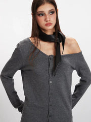 Detailed view of the model's upper body, showcasing the grey off-the-shoulder knit top and black scarf.