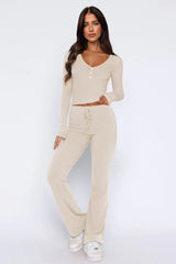 Woman wearing a cream ribbed knit long-sleeve top with button detail and matching flared pants, front view.