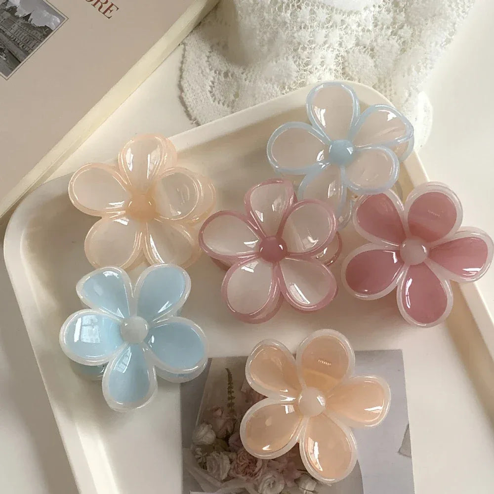 flower claw clips on a white tray with a pearl necklace and book in the background