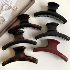 set of hair claw clips in various colors including black, tortoiseshell, and burgundy