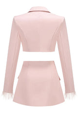 Pink cropped blazer and asymmetrical skirt with feather trim laid flat, back view