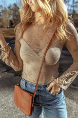 Front close-up of a woman wearing a tan lace long-sleeved top with a scoop neckline and bell sleeves, paired with blue denim jeans.