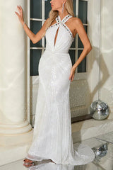 Model posing in a shimmering white sequined gown for a formal event.