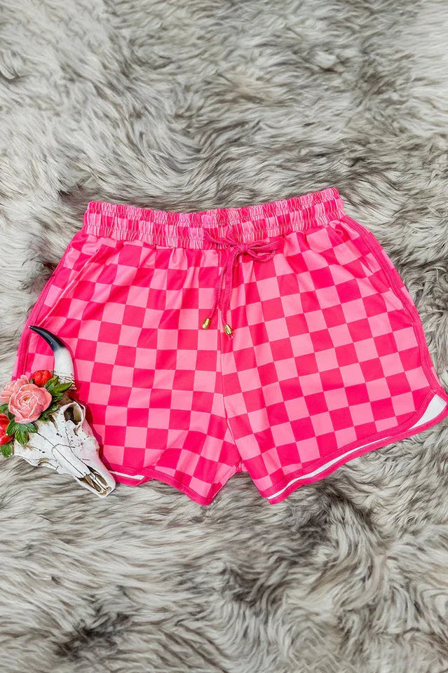 Pink checkerboard shorts on a furry surface with decorative skull