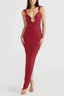 Woman wearing a long red sleeveless dress with a deep V-neck and a cutout detail at the bust.