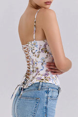 Side view of a woman wearing a floral print corset top with a lace-up back.
