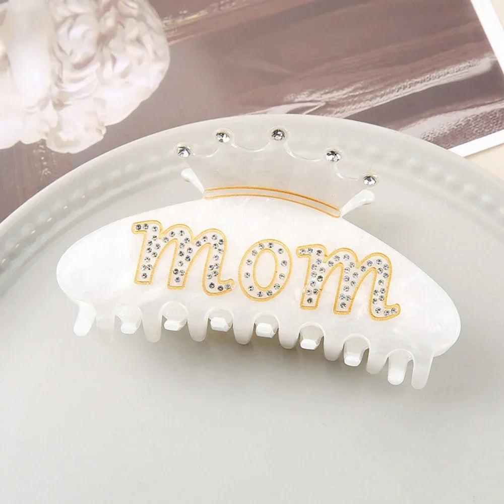 White claw clip with 'Mom' and a clear crown