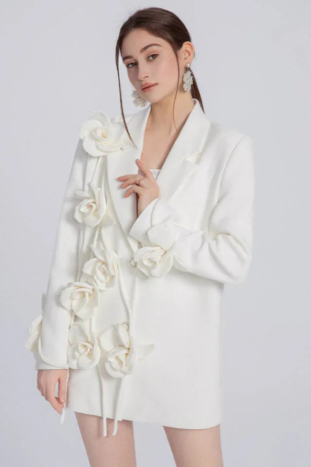 Woman wearing a white blazer dress with 3D floral embellishments