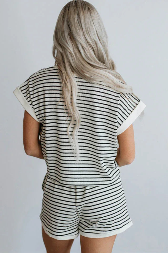 Woman wearing a black and white striped loungewear set, back view