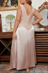 Rear view of a woman wearing a long satin nightgown with lace trim, standing.