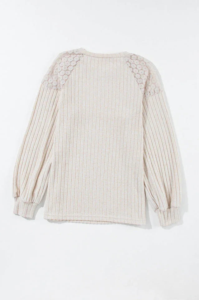 Back view of a cream ribbed knit sweater with lace shoulder detail, laid flat.