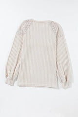 Back view of a cream ribbed knit sweater with lace shoulder detail, laid flat.