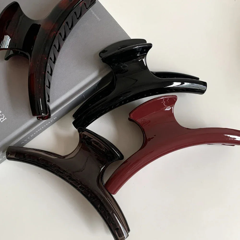 close-up of four hair claw clips in black, dark brown, burgundy, and tortoiseshell