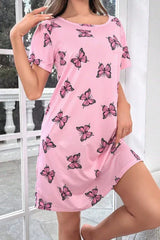 Woman wearing a pink short-sleeve nightgown with a butterfly print, posing indoors.