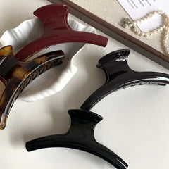 group of hair claw clips in a white bowl and on a white surface