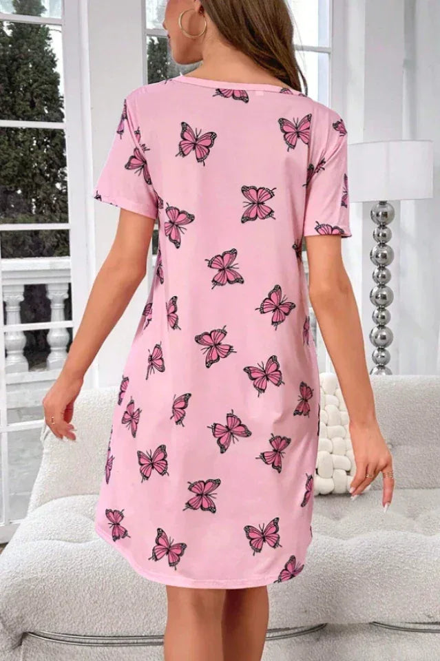 Back view of a woman wearing a pink short-sleeve nightgown with a butterfly print.