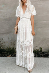 woman in a white lace maxi dress with blonde hair, holding a light-colored clutch