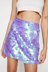 Close-up of a woman's midriff and a purple iridescent sequin mini skirt.
