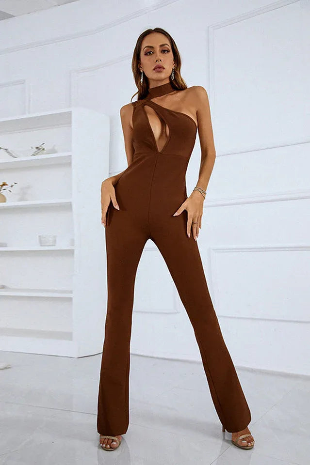 Woman posing in a brown one-shoulder jumpsuit with a cut-out detail and flared legs.
