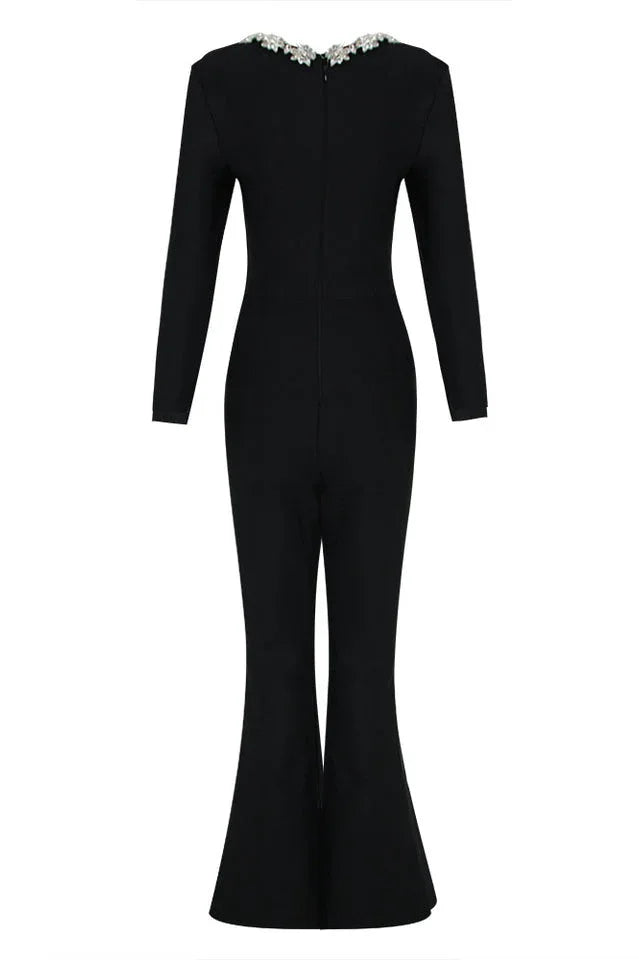 Rear view of a black velvet jumpsuit with long sleeves and flared legs.