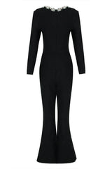 Rear view of a black velvet jumpsuit with long sleeves and flared legs.