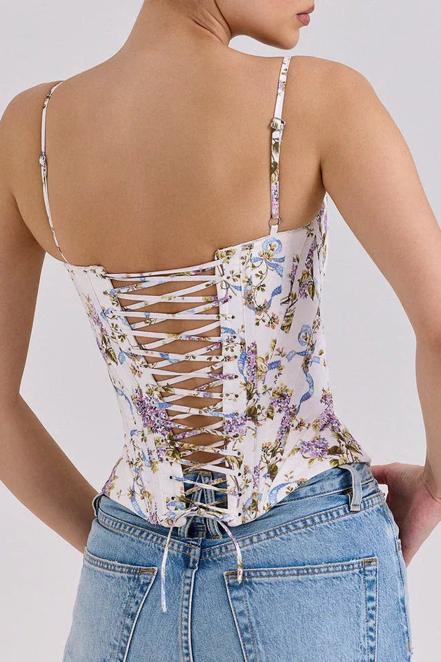 Back view of a woman in a floral print corset top showcasing the lace-up detail.