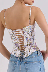 Back view of a woman in a floral print corset top showcasing the lace-up detail.