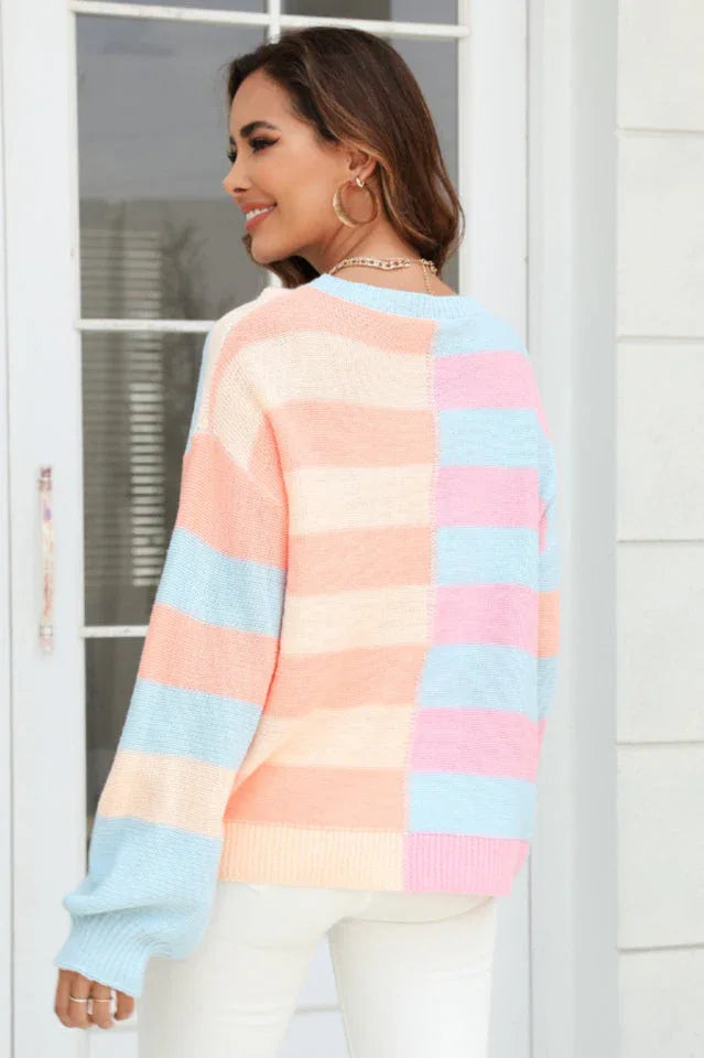 Back view of a woman wearing a pastel striped color-block knit sweater