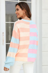Back view of a woman wearing a pastel striped color-block knit sweater