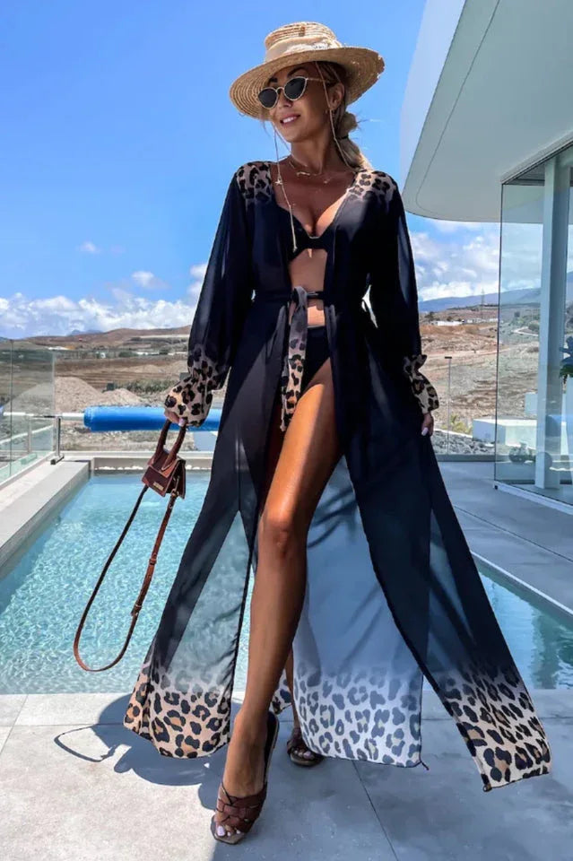 Woman wearing a black leopard print trim maxi duster over a black bikini